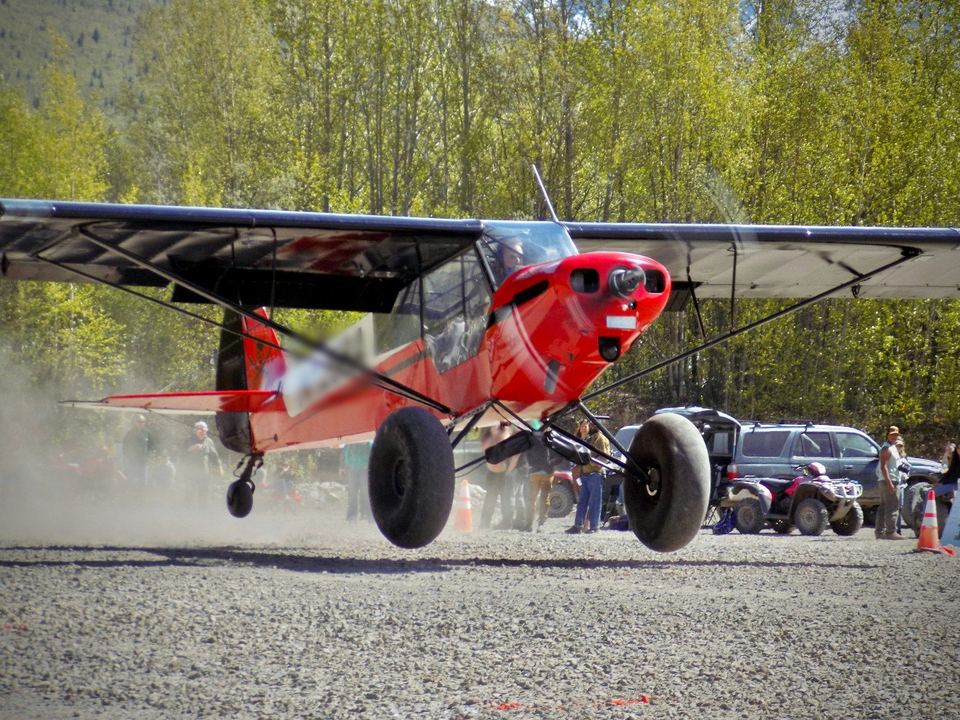 A Super Cub takes off in front of spectators at the Sourdough Fly-in in Port Alsworth, Alaska.